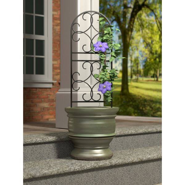 Pretty trellis stood in a pot outside  a house with flowers growing up it