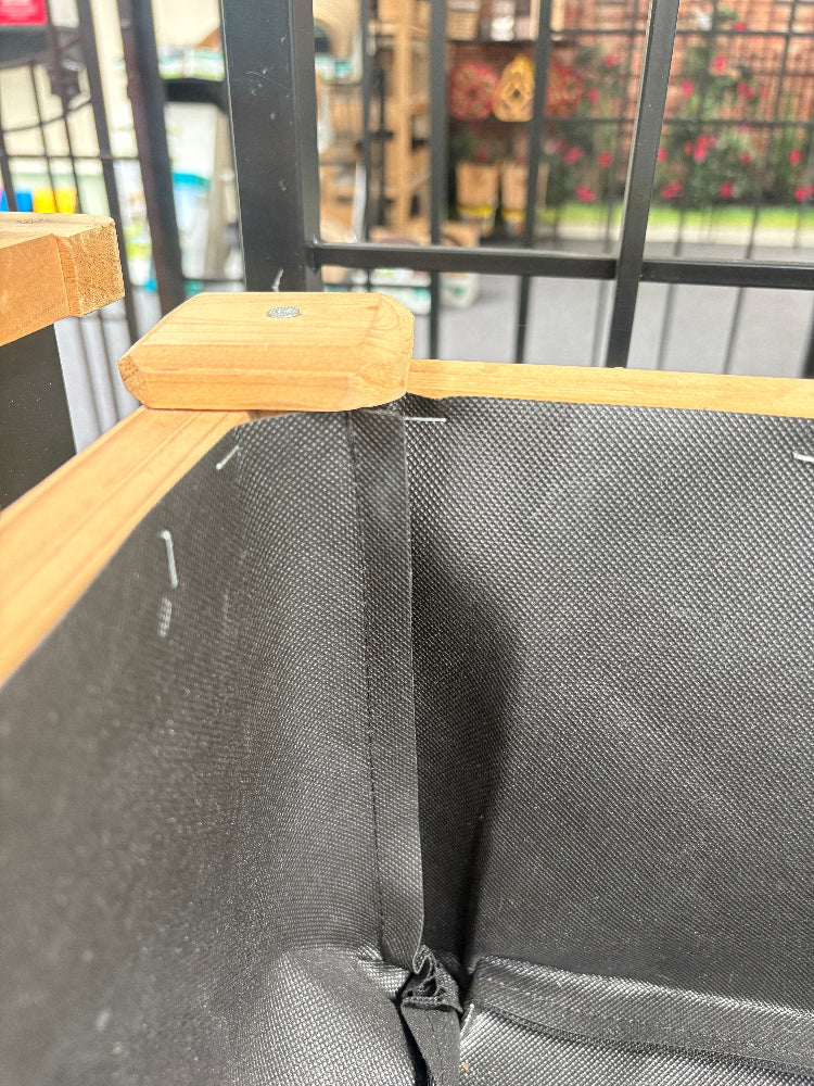 Close-up of a black bag with a wooden handle, blurred background