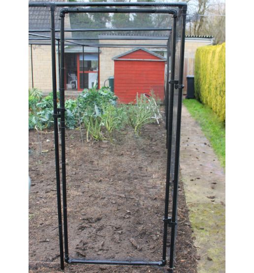 A black metal fruit cage door kit installed on a frame with a garden and house in the background.