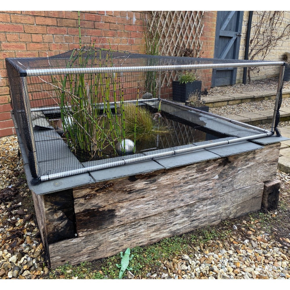 aluminium frame covering with black butterfly netting raised above a pond
