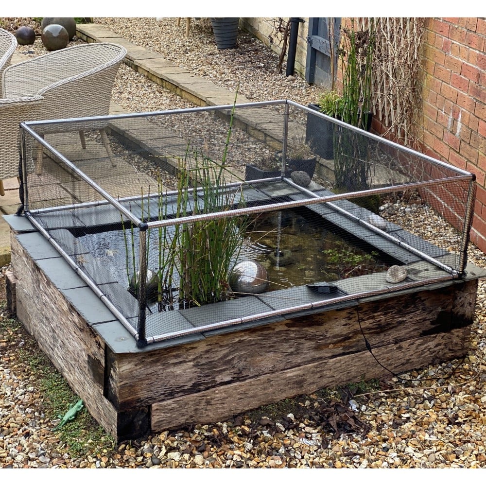 aluminium frame covering with black butterfly netting raised above a pond