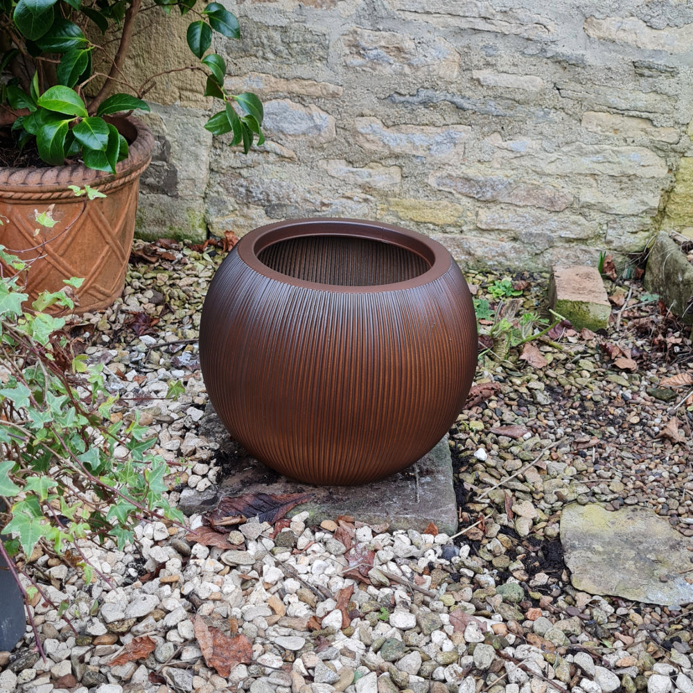 ridged cedar ball plant pot in garden
