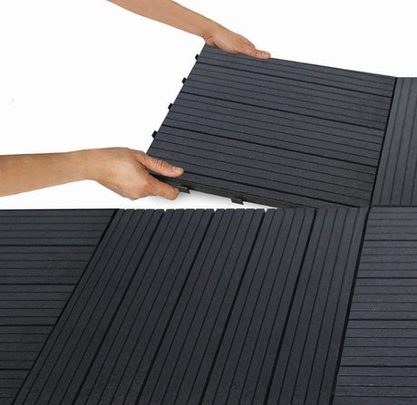 Decking tiles being laid by person