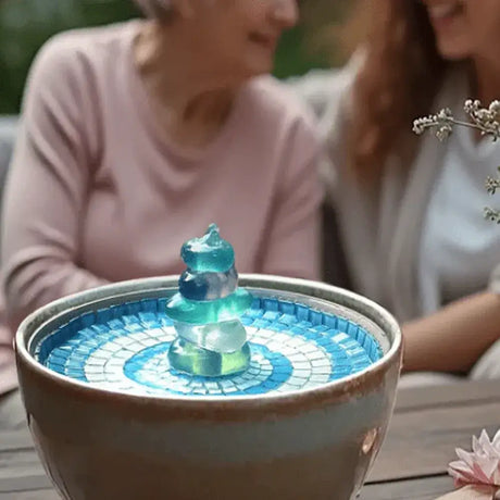 Seaglass pebbles in hydria fountain with two ladies behind chatting