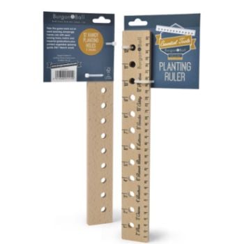 A wooden seed and plant spacing ruler with markings for planting veg