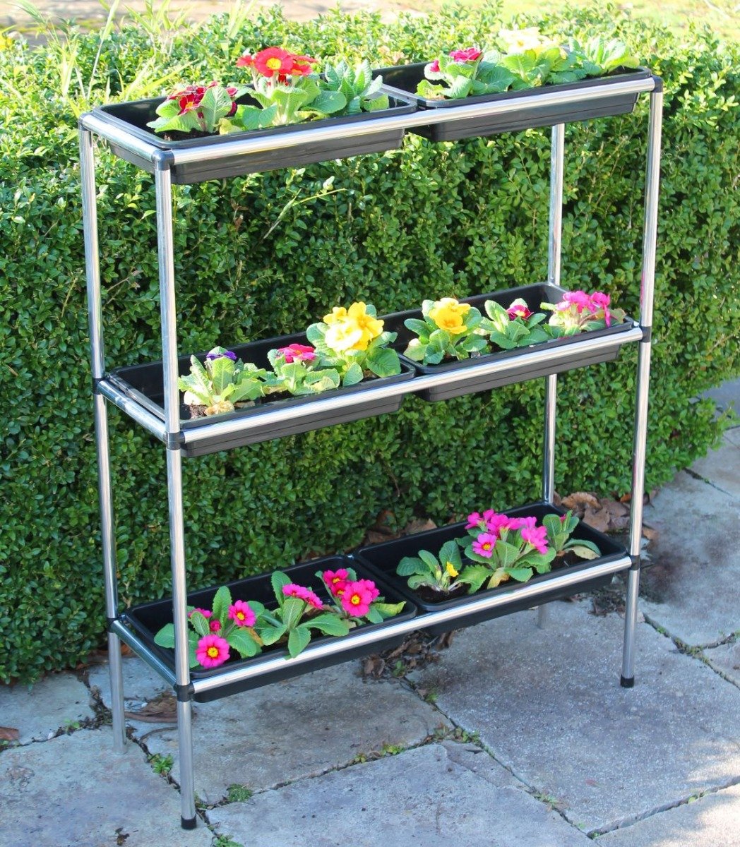 A three-tiered seed tray stand made of aluminum, with each tier holding two seed trays
