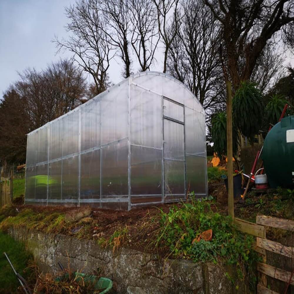 side view of a greenhouse in a garden on a grass ledge