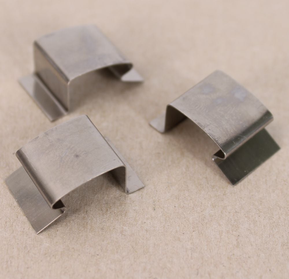 Three silver stainless steel sprung greenhouse glass clips