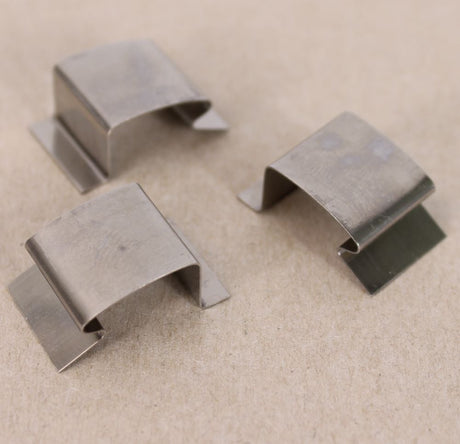 Three silver stainless steel sprung greenhouse glass clips