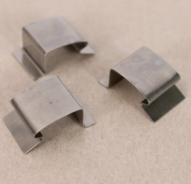 Three silver stainless steel sprung greenhouse glass clips
