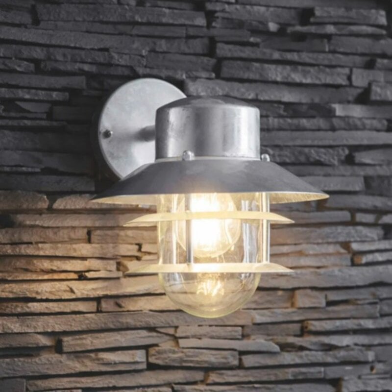 A silver Strand down light with a industrial caged design, mounted on an exterior wall with a stone finish.