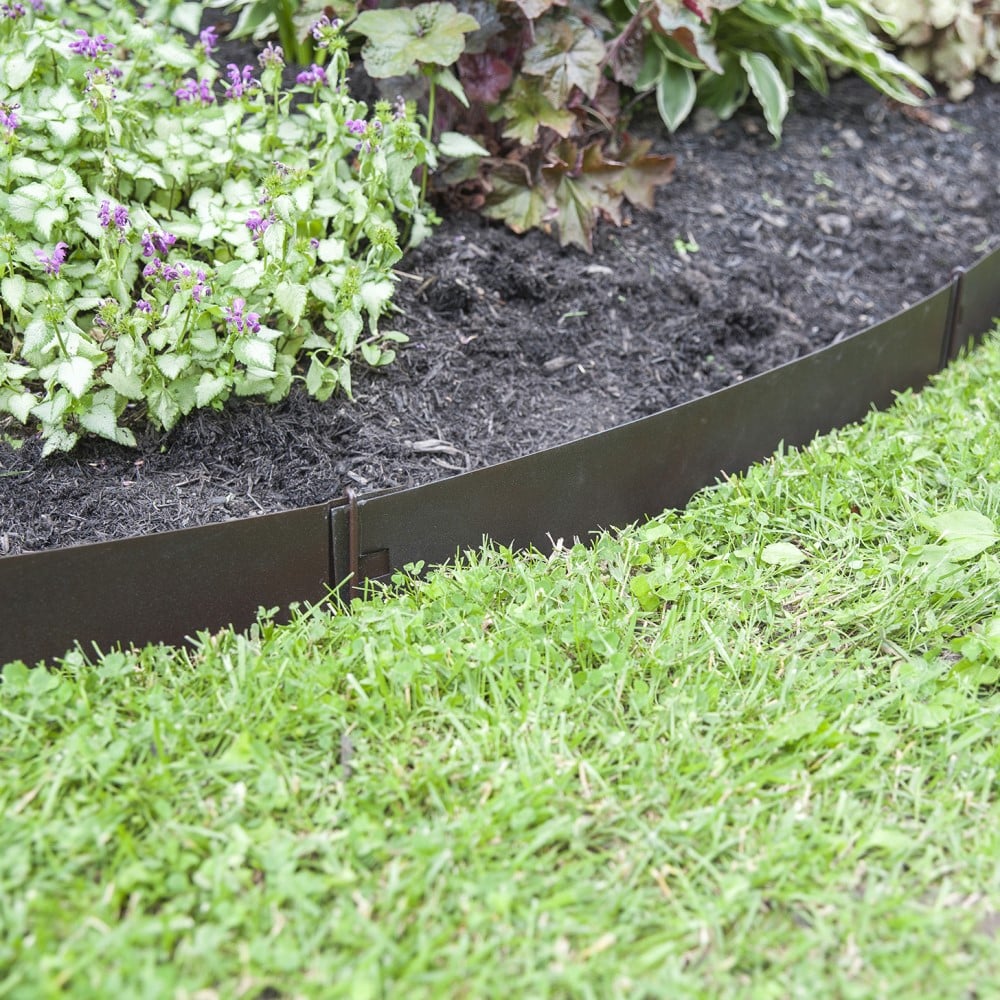 A black, metal landscaping border kit installed around a flowerbed, with green grass in the foreground.