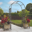 Huntingdon Ornamental Arch with Planter Holders in a colourful garden with a blue sky