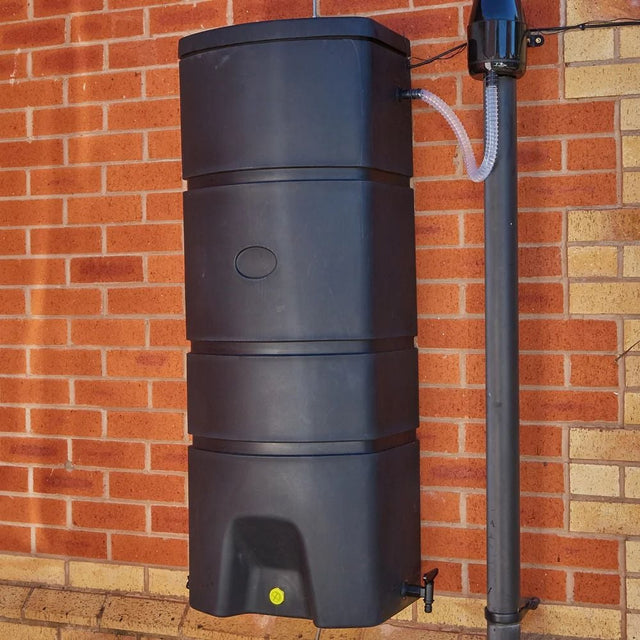 A black wall mounted 160L Terracottage water butt with a visible tap, mounted on a brick wall.