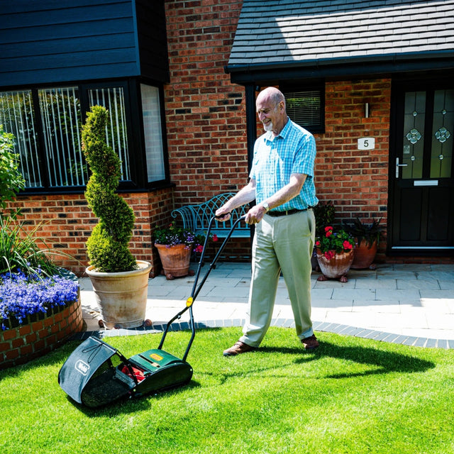 hand push lawnmower in garden cutting grass