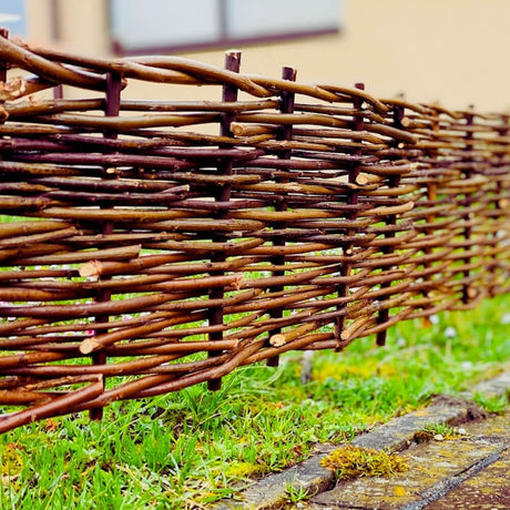 Side view of woven wooden trellis on lawn edge
