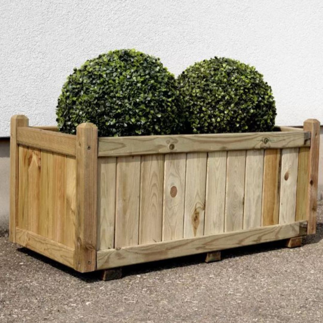 Wooden planter box with two green plants against a light gray background