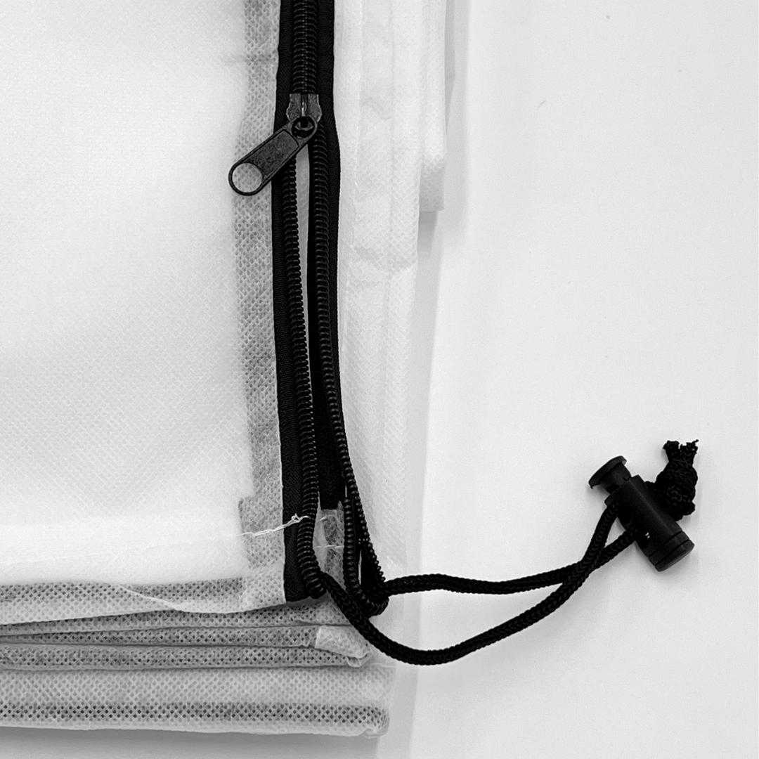 Close-up of a black zipper on a white garden fleece bag on a white background