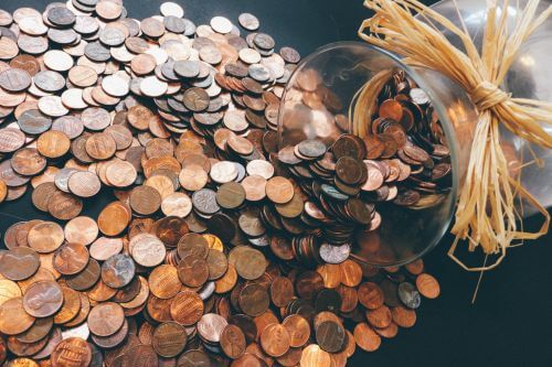 Lots of pennies in a jar showing how to save money gardening