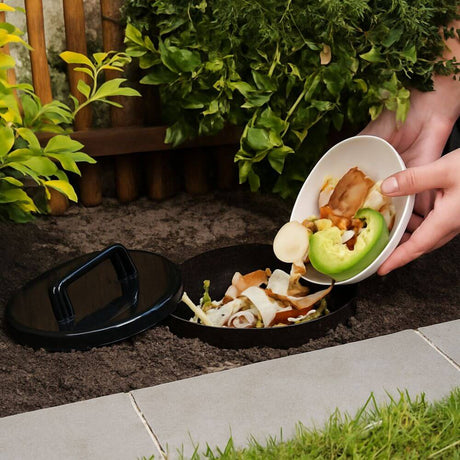 image shows buried composter with food being added