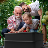 3 people filling wormery with vegetables looks like 3 generations