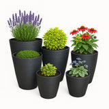 Set of black planters with various plants and flowers on a white background