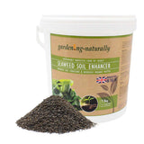 Seaweed soil enhancer in a 7.5kg tub with a pile of natural seaweed granules.