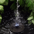Solar fountain in pond surrounded with plants