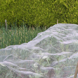 Vegetable garden with rows covered by a protective netting against pests.