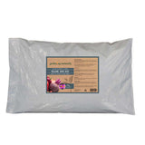 A large white plastic bag of gardening-naturally Volcanic Rock Dust, featuring a rectangular label with product details and illustrations of vegetables on a white background.