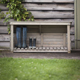 Wooden wellie store in garden with boots in it