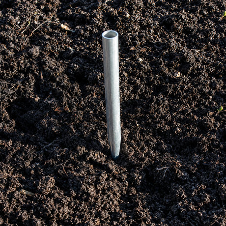 Metal stake driven into dark soil