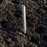 Metal stake driven into dark soil