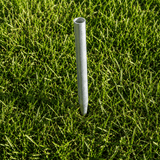 Metal pipe standing upright in green grass