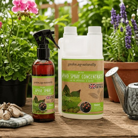 Garden spray bottles with labels on a wooden table with plants in the background