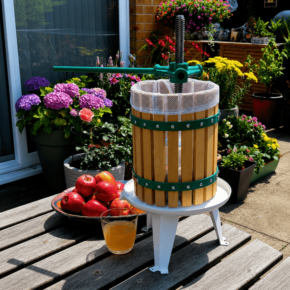 Wooden cider press with apples and juice on a wooden table outdoors.