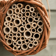 Bee hotel made of natural materials with wooden tubes.