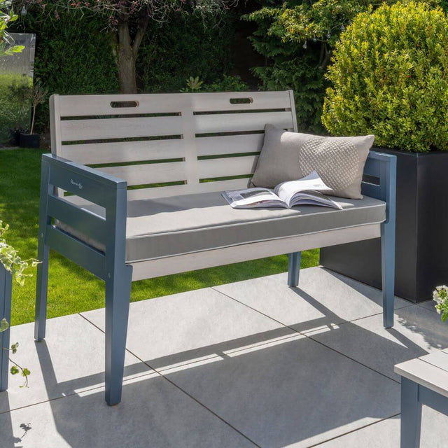 garden grey bench with cushion and book