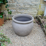 stone effect grey garden pot or planter in garden on gravel