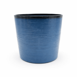 Blue planter with black interior on a white background