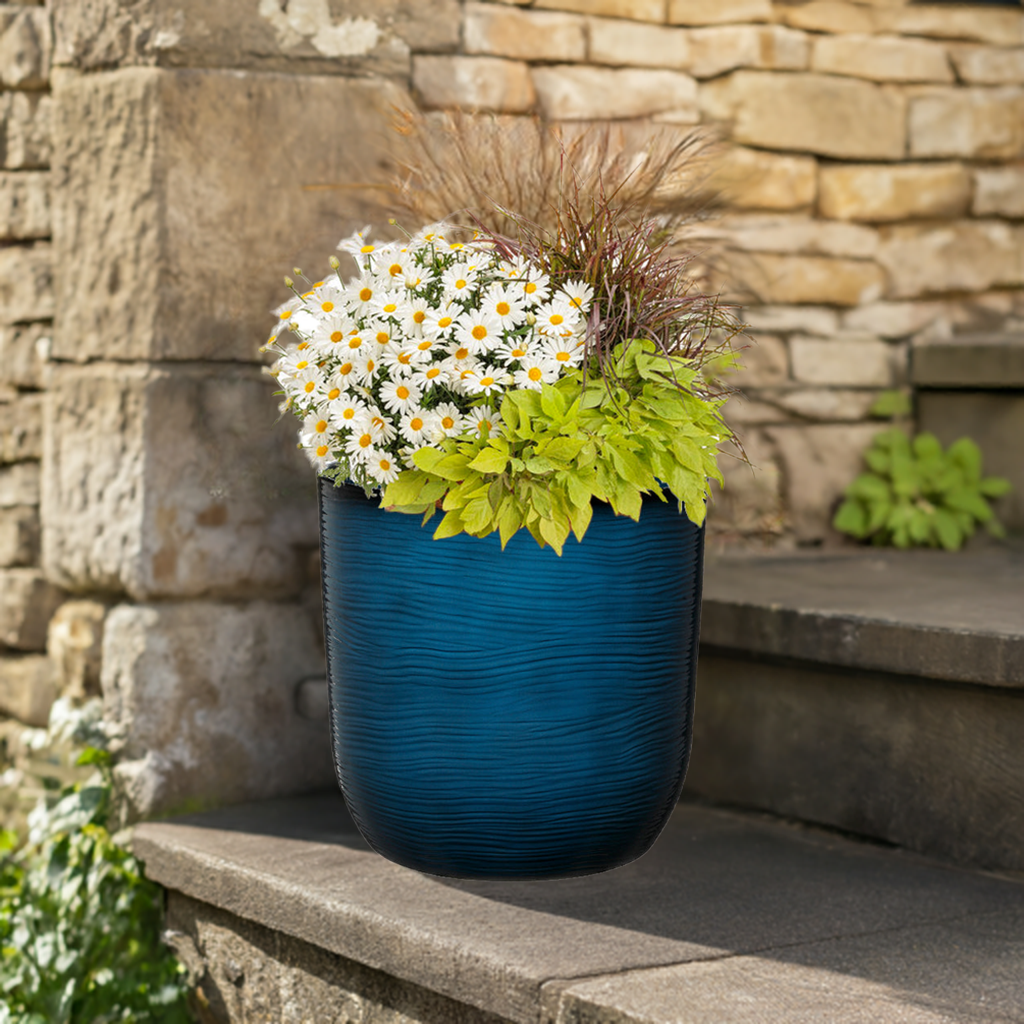 blue plant pot with flowers sat on step