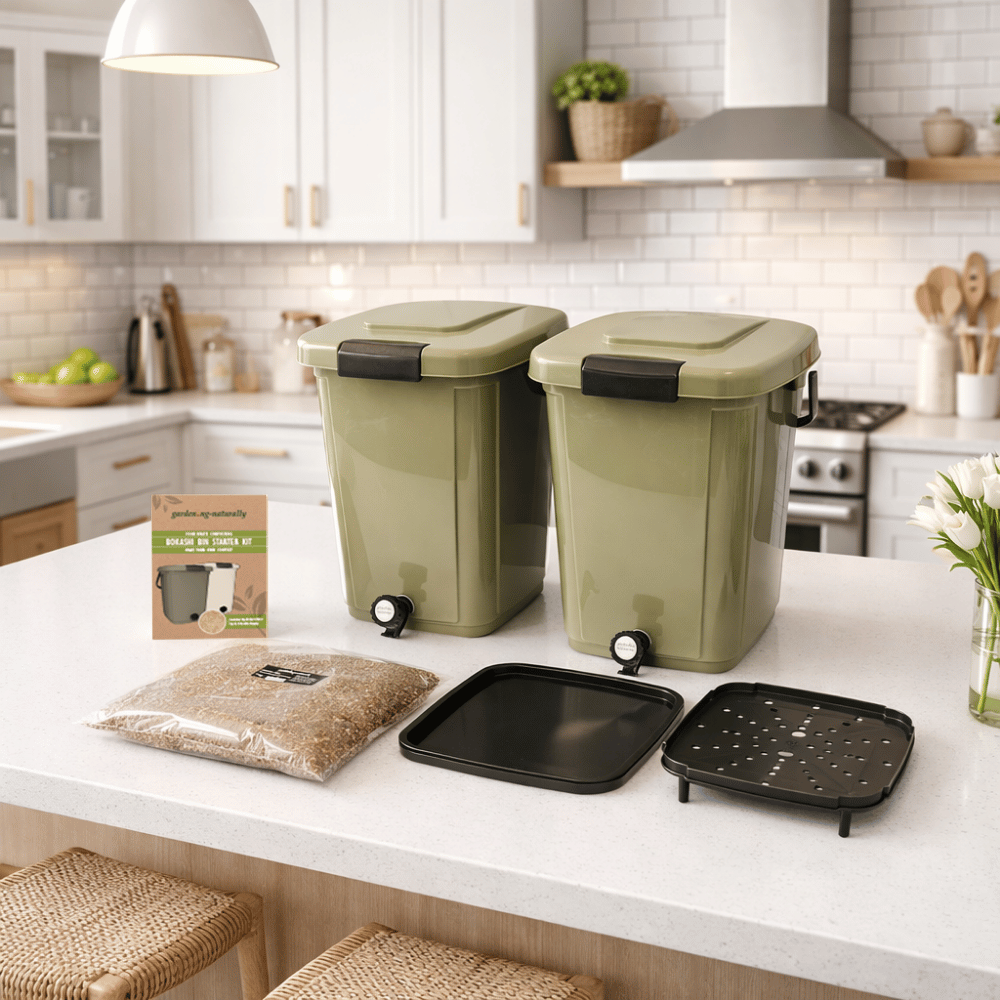 Two green trash bins on a kitchen counter with kitchen items in the background.