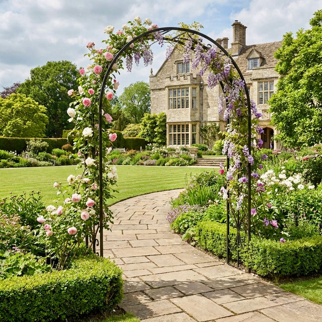 Floral archway in a garden with a stately home in the background