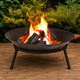 Cast iron Fire pit with flames and glowing embers on a brick patio