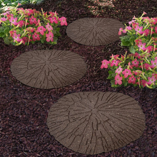 Circular stepping stones in garden on bark with flowers