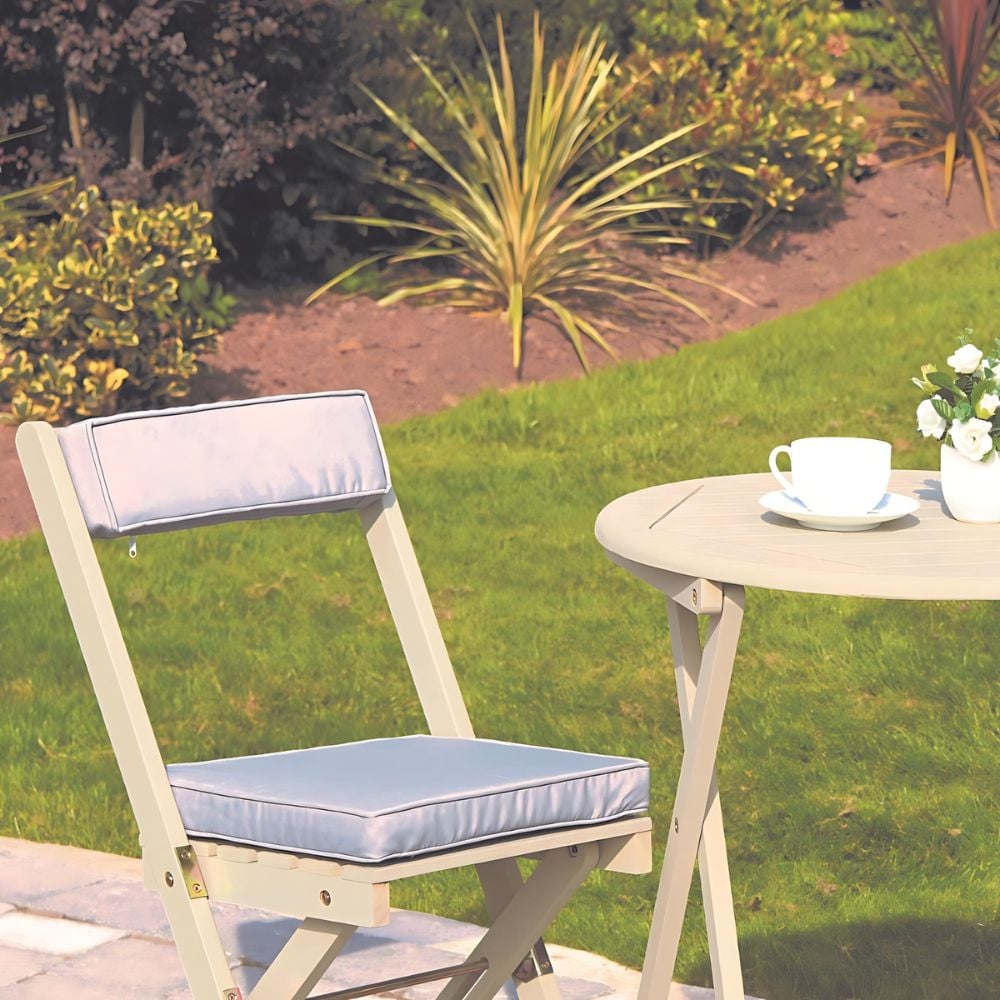 cream white chair and table set in garden with drink