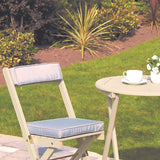 cream white chair and table set in garden with drink