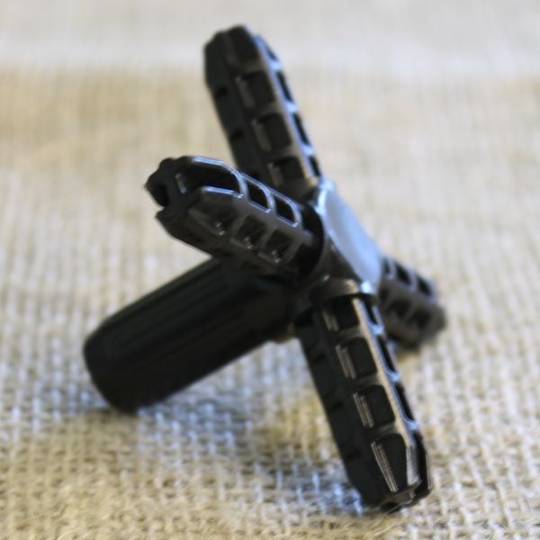 A black plastic cross-shaped cage connector joiner