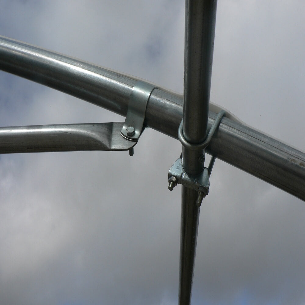Close-up of a metal frame with bolts against a cloudy sky.