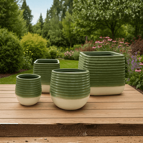 Set of green ceramic planters on a wooden deck with a garden background